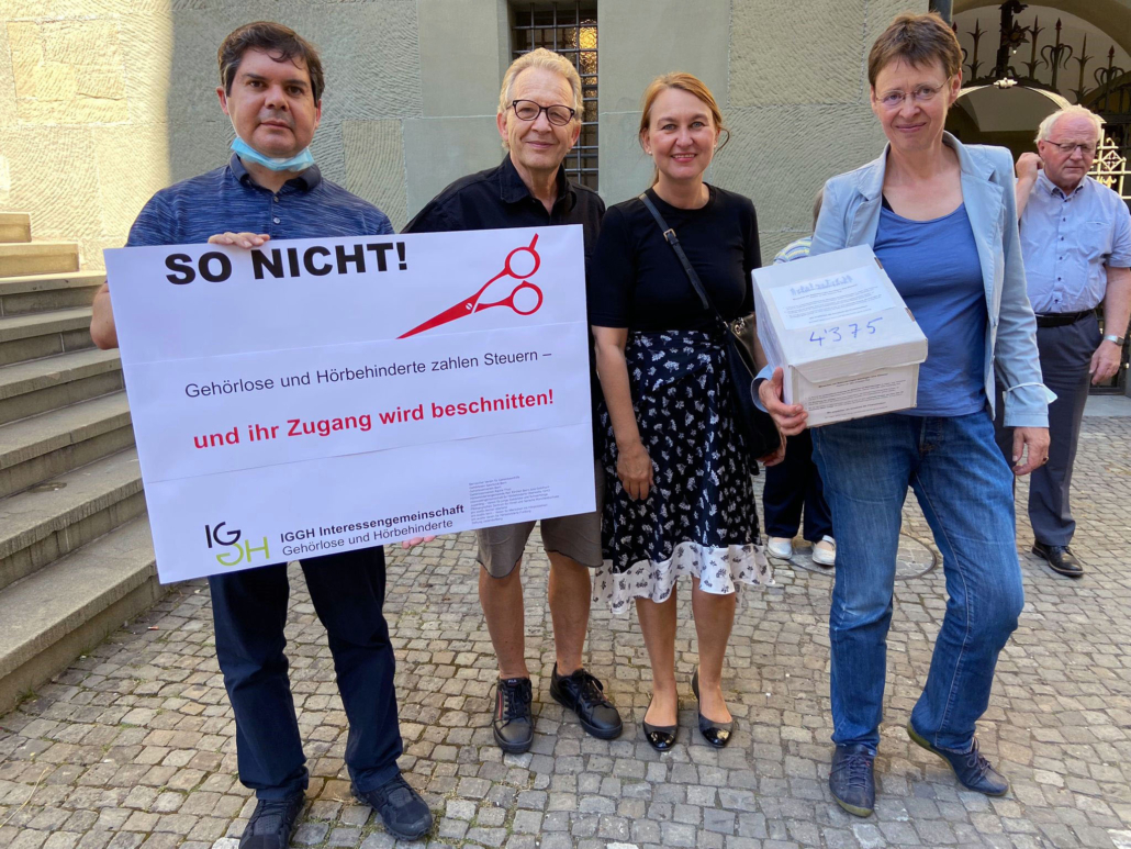 Plakat: So nicht! Gehörlose und Hörbehinderte zahlen Steuern - und ihr Zugang wird beschnitten. Von links: Victor Senn, Beat Ledermann, Brigitte Schökle und Yvonne Brütsch