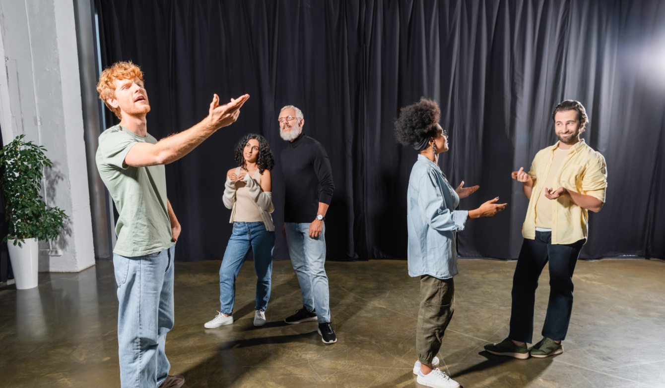 Illustrationsbild einer Theaterprobe mit fünf Personen, mit diversen Gesten.