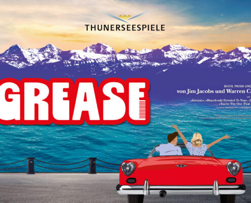 Im Vordergrund steht ein rotes Cabriolet, von hinten zu sehen. Darin sitzen zwei Personen, die fröhlich die Arme heben, als würden sie den Moment feiern. Vor ihnen glitzert der Thunersee in kräftigem Türkis. Dahinter ragen die verschneiten Alpen in die Höhe, violett getönt wie ein Bühnenhintergrund kurz vor der Premiere. Oben im Bild prangt das Logo der Thunerseespiele. Links steht gross ‹GREASE› in roter Schrift mit einem stilisierten Kamm. Die Szene wirkt wie ein Versprechen auf Sommer, Musik und eine Prise Rock’n’Roll.